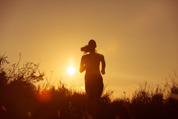 Female runner running at sunset.