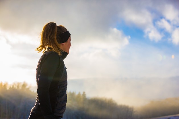 A female trail runs in the fog and snow of winter.