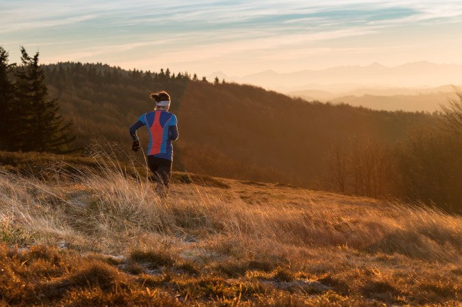 woman running alone in the mountains in the morning
